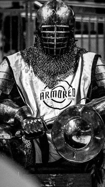 Armored League fighter in full plate armor and chainmail, holding a sword and shield